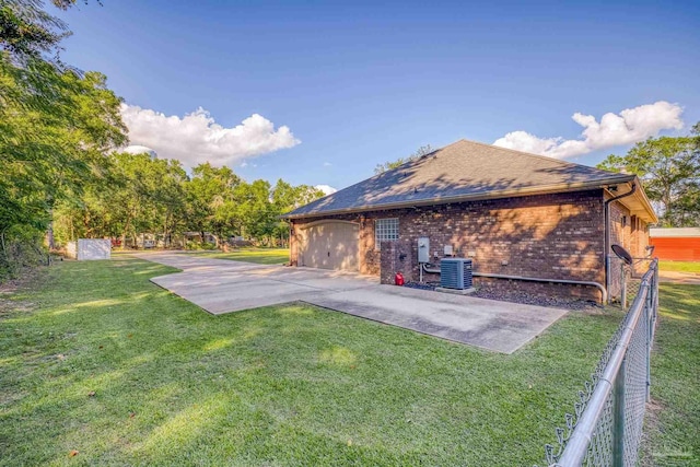 view of side of property with a yard, a patio area, and central AC