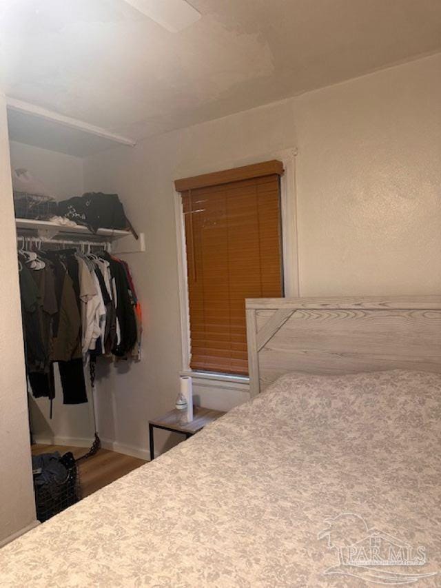 bedroom with a closet and hardwood / wood-style floors