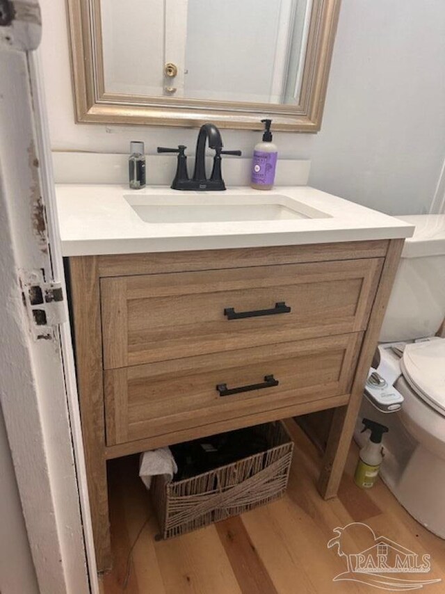 bathroom featuring vanity, hardwood / wood-style flooring, and toilet