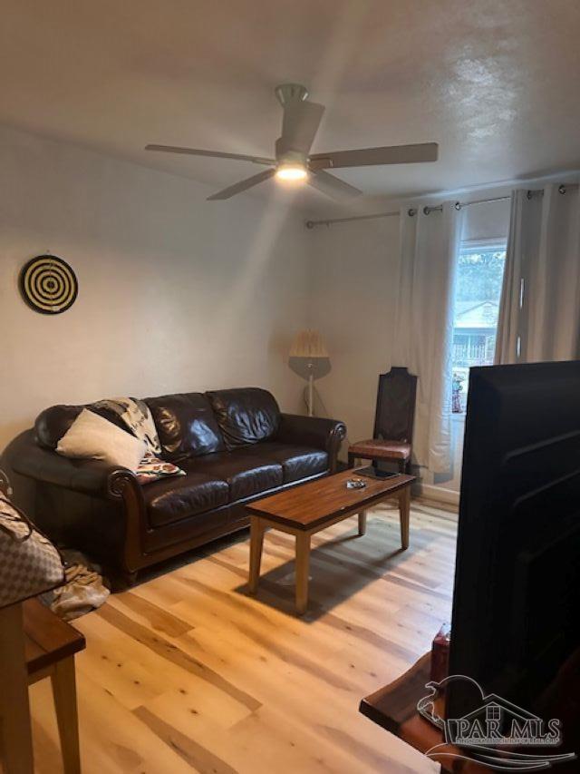 living room with hardwood / wood-style floors and ceiling fan