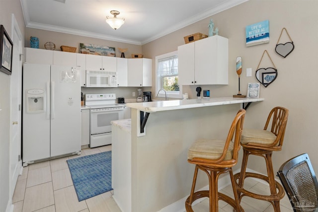 kitchen featuring a breakfast bar area, ornamental molding, white appliances, and kitchen peninsula