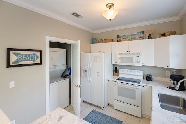 kitchen with light tile patterned floors, crown molding, white appliances, stacked washing maching and dryer, and sink