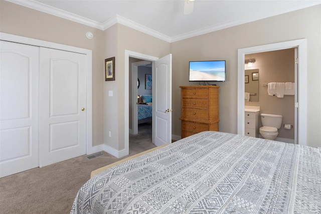 carpeted bedroom with ornamental molding, ensuite bathroom, ceiling fan, and a closet