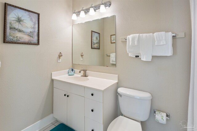 bathroom with vanity, toilet, and tile patterned floors