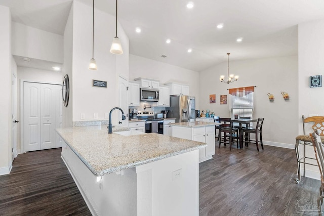 kitchen featuring appliances with stainless steel finishes, a sink, an inviting chandelier, and dark wood-type flooring