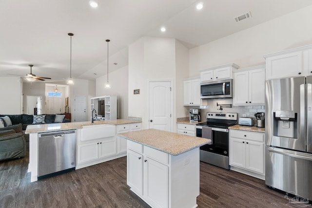 kitchen featuring visible vents, a ceiling fan, open floor plan, a sink, and stainless steel appliances
