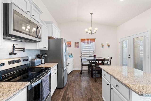kitchen featuring stainless steel appliances, vaulted ceiling, a wealth of natural light, and dark wood-type flooring