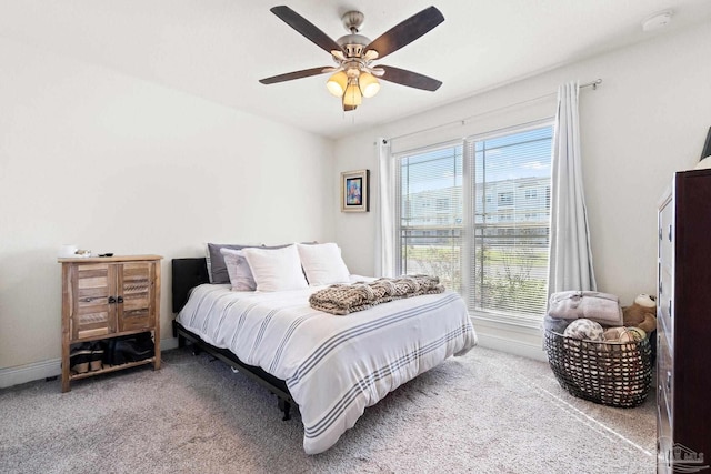bedroom featuring a ceiling fan, carpet, and multiple windows