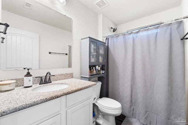 bathroom with vanity, toilet, curtained shower, and visible vents