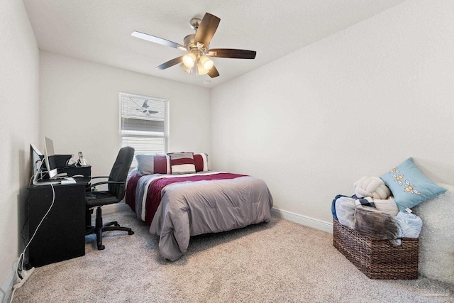 carpeted bedroom featuring baseboards and a ceiling fan