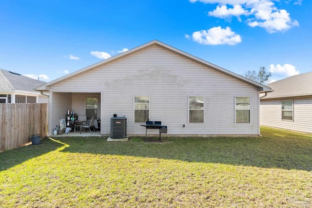 rear view of house with a lawn, a patio area, fence, and cooling unit