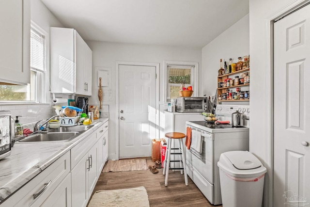 kitchen with light stone countertops, sink, white range with electric cooktop, white cabinetry, and dark hardwood / wood-style floors