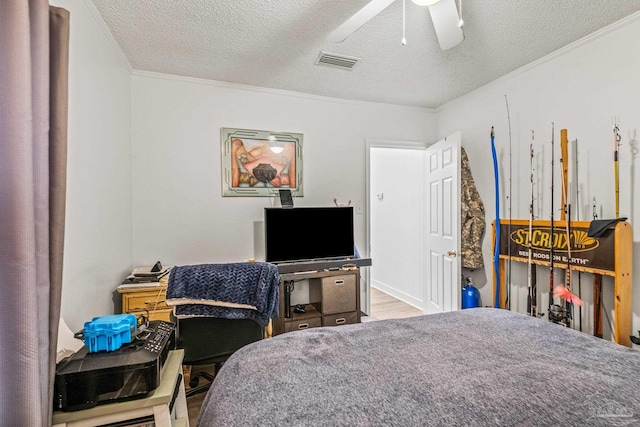 bedroom with ornamental molding, a textured ceiling, hardwood / wood-style floors, and ceiling fan