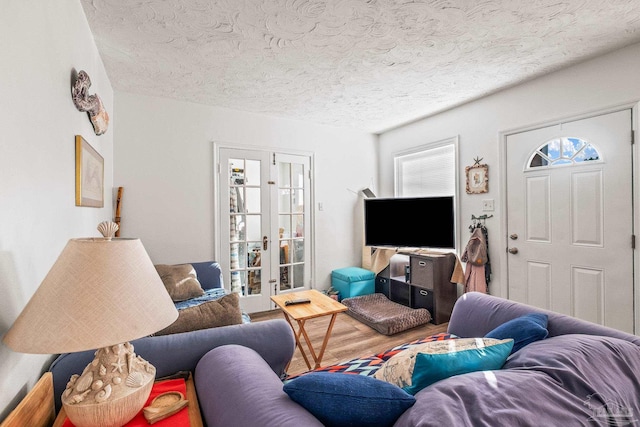 living room with french doors, wood-type flooring, and a textured ceiling