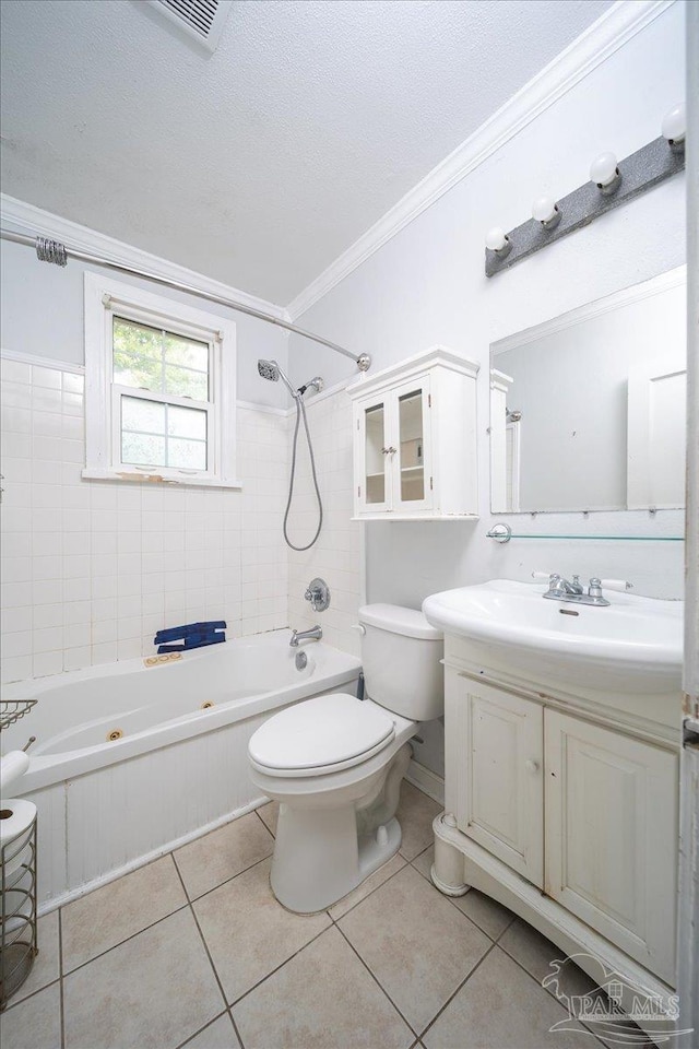 full bathroom featuring tile patterned floors, ornamental molding, vanity, tiled shower / bath combo, and toilet