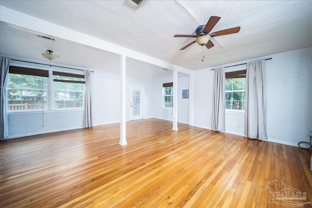 spare room with a textured ceiling, light wood-type flooring, and ceiling fan