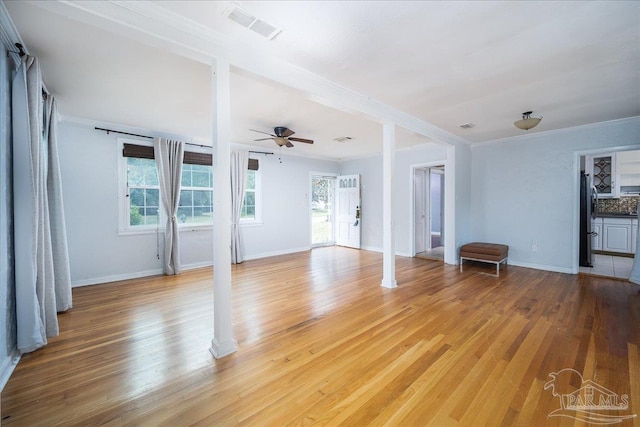 unfurnished living room featuring hardwood / wood-style flooring, ceiling fan, and ornamental molding