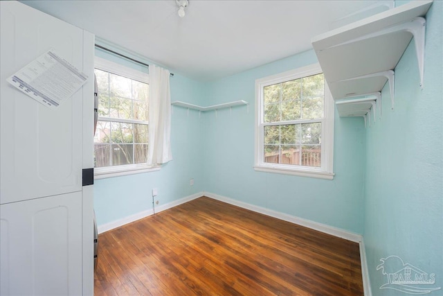 empty room with plenty of natural light and dark wood-type flooring