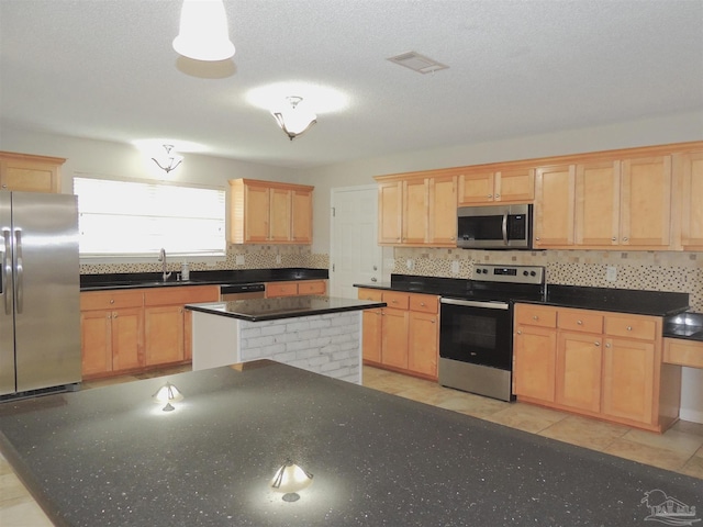4814 Belvedere Cir, Pace, FL 32571 - kitchen with appliances with stainless steel finishes, light brown cabinets, a kitchen island, and tasteful backsplash