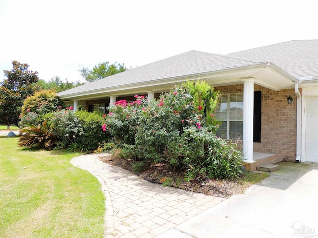 4814 Belvedere Cir, Pace, FL 32571 - view of side of property featuring brick siding, a shingled roof, a yard, and an attached garage
