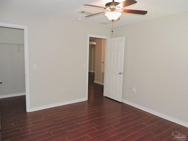 4814 Belvedere Cir, Pace, FL 32571 - unfurnished bedroom with dark wood-type flooring, a closet, a ceiling fan, and a walk in closet