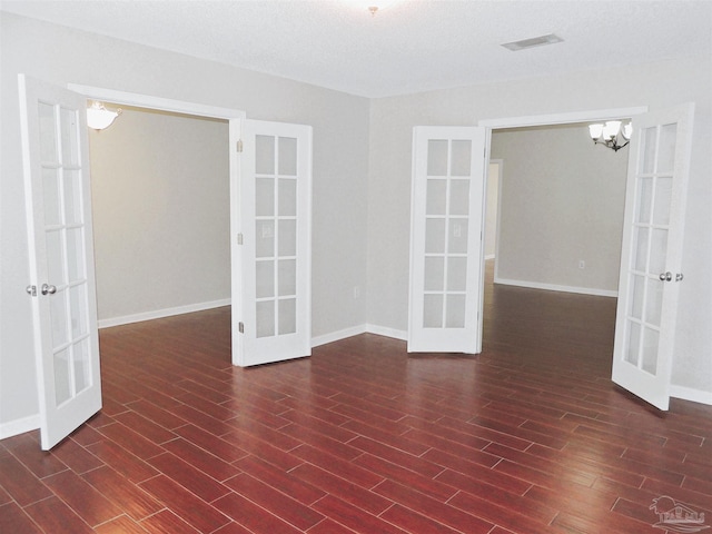 4814 Belvedere Cir, Pace, FL 32571 - empty room featuring french doors, dark wood-type flooring, and a chandelier