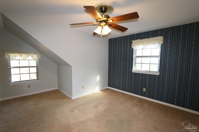 additional living space featuring light carpet, vaulted ceiling, and ceiling fan