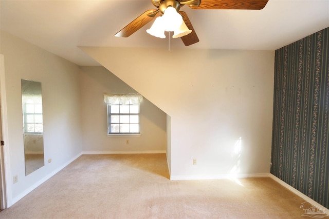 bonus room with light carpet and ceiling fan