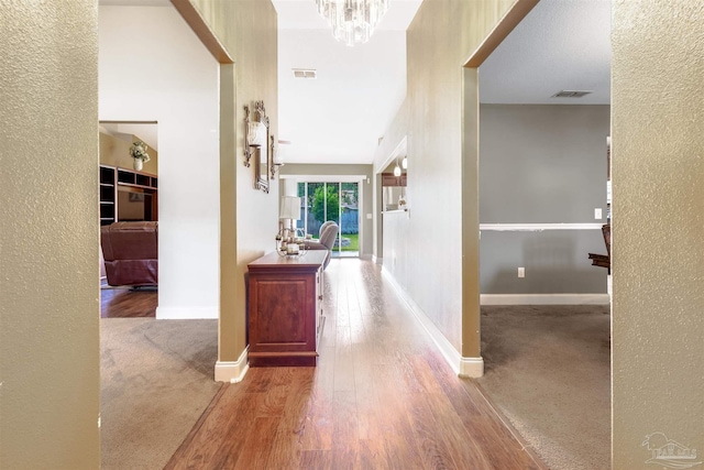 2546 Stormy Cir, Navarre, FL 32566 - corridor with a textured wall, visible vents, and an inviting chandelier