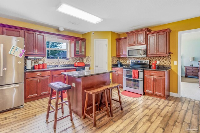 2546 Stormy Cir, Navarre, FL 32566 - kitchen featuring a sink, light wood finished floors, decorative backsplash, and stainless steel appliances