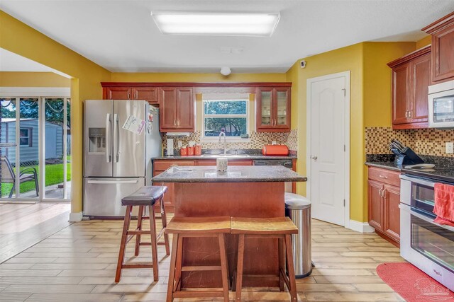 2546 Stormy Cir, Navarre, FL 32566 - kitchen featuring a kitchen island, tasteful backsplash, a sink, light wood finished floors, and stainless steel appliances