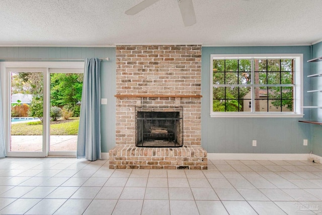 unfurnished living room featuring a textured ceiling, ceiling fan, light tile patterned flooring, and a fireplace