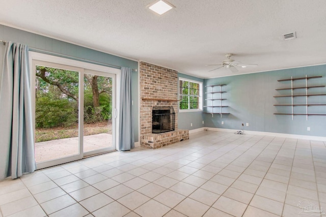 unfurnished living room with ceiling fan, a fireplace, light tile patterned floors, and a textured ceiling