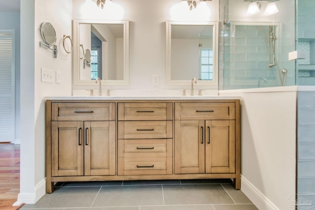 bathroom featuring tile patterned floors, vanity, and a tile shower