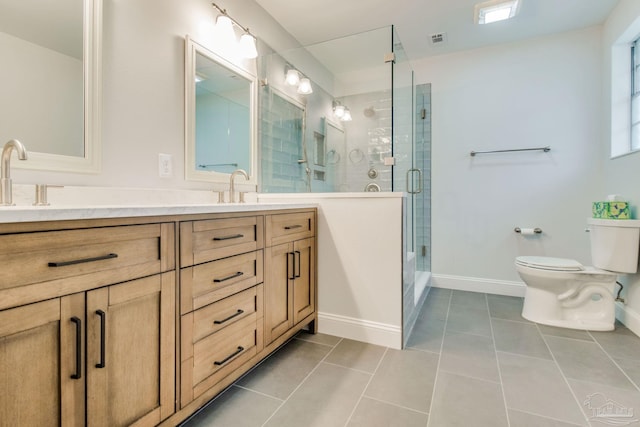 bathroom featuring tile patterned flooring, vanity, toilet, and a shower with door