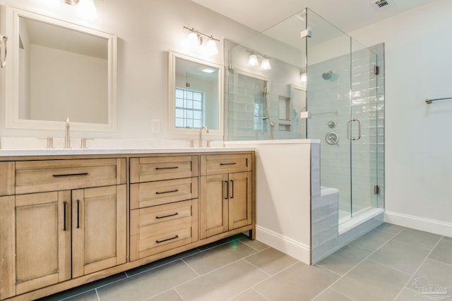 bathroom with tile patterned floors, vanity, and walk in shower