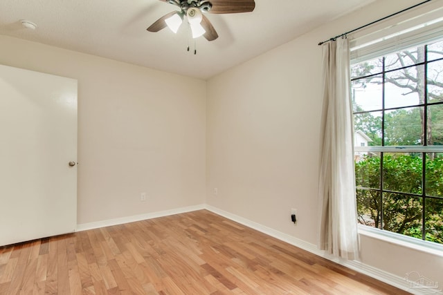 unfurnished room with a wealth of natural light, ceiling fan, and light hardwood / wood-style floors