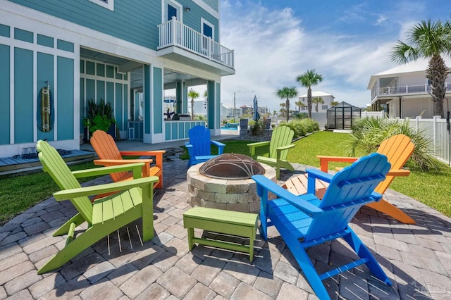 view of patio with a balcony and an outdoor fire pit