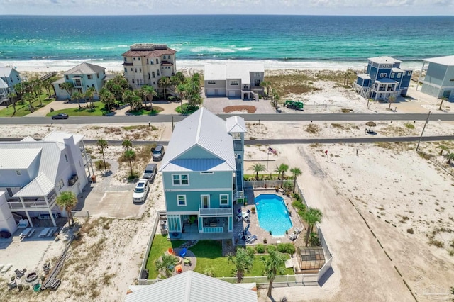 birds eye view of property with a water view and a beach view