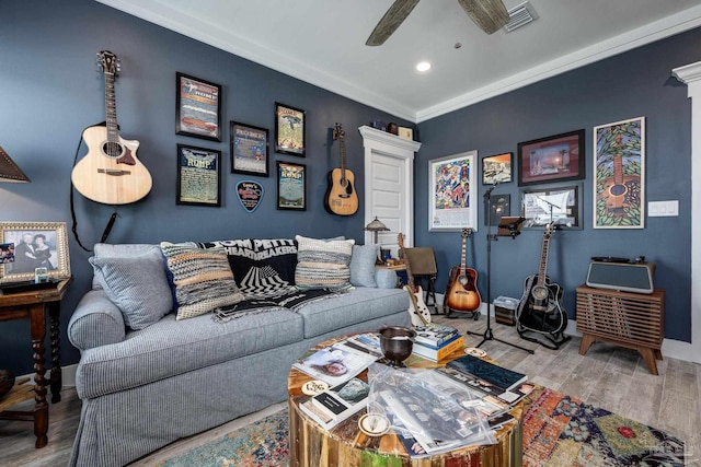 living room featuring crown molding, light hardwood / wood-style flooring, and ceiling fan