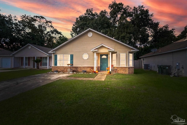 view of front of home with cooling unit and a yard