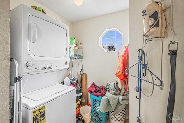 clothes washing area with stacked washer / dryer