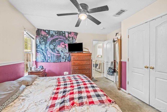 carpeted bedroom featuring ceiling fan, a textured ceiling, and a closet