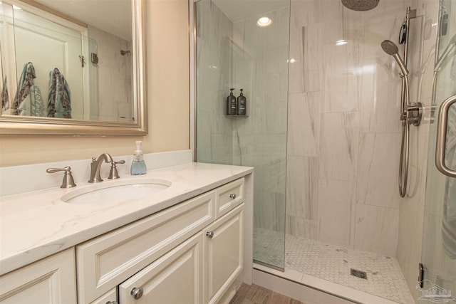 bathroom with a shower with door and vanity