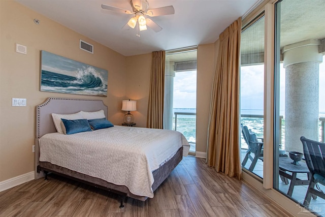 bedroom with multiple windows, ceiling fan, and wood-type flooring