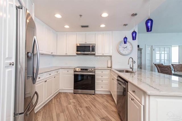 kitchen featuring sink, appliances with stainless steel finishes, light stone counters, light hardwood / wood-style floors, and white cabinetry