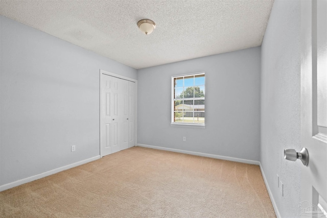 carpeted empty room with a textured ceiling