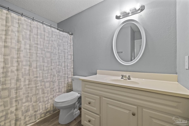 bathroom with vanity, hardwood / wood-style floors, toilet, and a textured ceiling