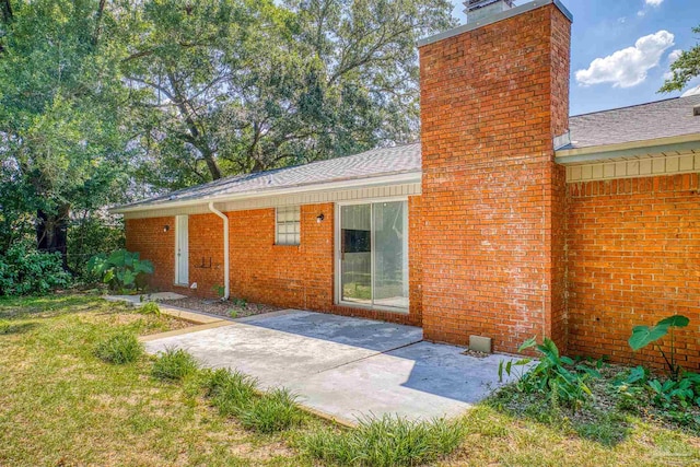 back of property with a lawn and a patio area