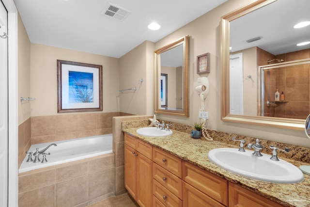bathroom featuring a shower stall, a garden tub, a sink, and visible vents